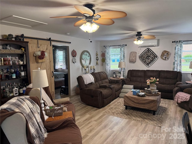 1895 Sandy Cir, Newton, NC 28658 - living room with an AC wall unit, a ceiling fan, wood finished floors, and healthy amount of natural light