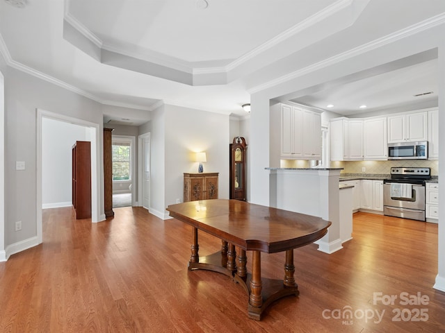 10875 Casetta Dr, Matthews, NC 28105 - dining space with wood finished floors, a raised ceiling, recessed lighting, and ornamental molding