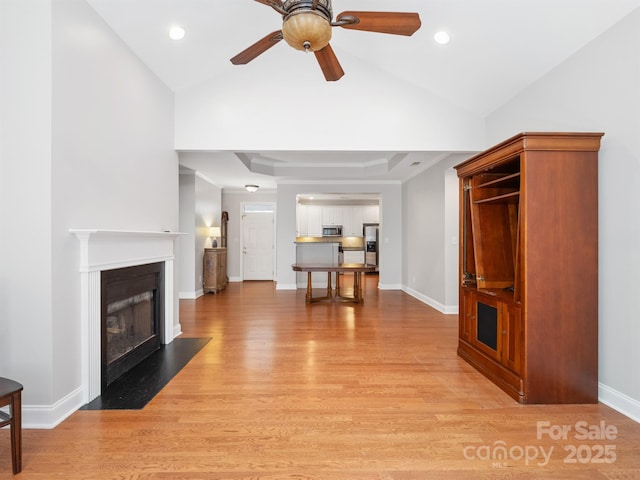 10875 Casetta Dr, Matthews, NC 28105 - living area with light wood-type flooring, a ceiling fan, a fireplace with flush hearth, lofted ceiling, and recessed lighting