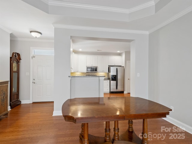 10875 Casetta Dr, Matthews, NC 28105 - dining space with wood finished floors, ornamental molding, and a tray ceiling