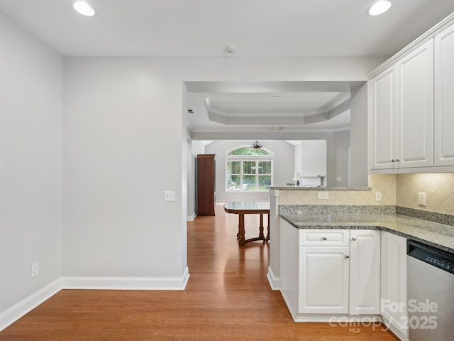 10875 Casetta Dr, Matthews, NC 28105 - kitchen featuring stainless steel dishwasher, a tray ceiling, light wood-style floors, white cabinets, and recessed lighting