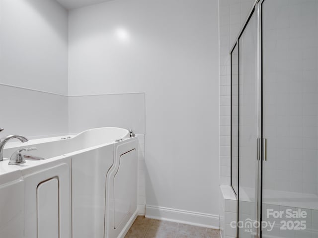 10875 Casetta Dr, Matthews, NC 28105 - bathroom with a shower stall, a bath, tile patterned floors, and washer / clothes dryer