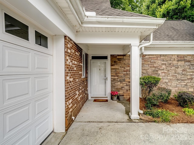 10875 Casetta Dr, Matthews, NC 28105 - property entrance with roof with shingles, brick siding, a porch, and a garage