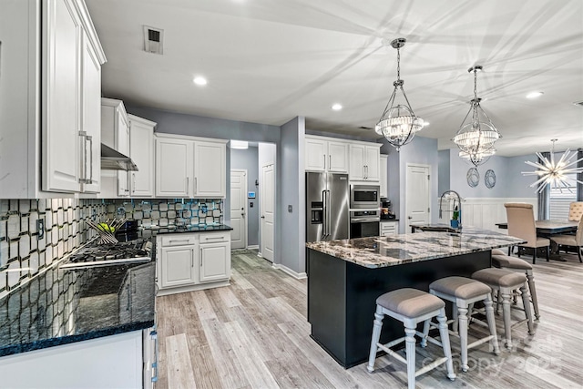 7809 Creek Park Dr, Denver, NC 28037 - kitchen featuring appliances with stainless steel finishes, a chandelier, a sink, white cabinetry, and dark stone counters
