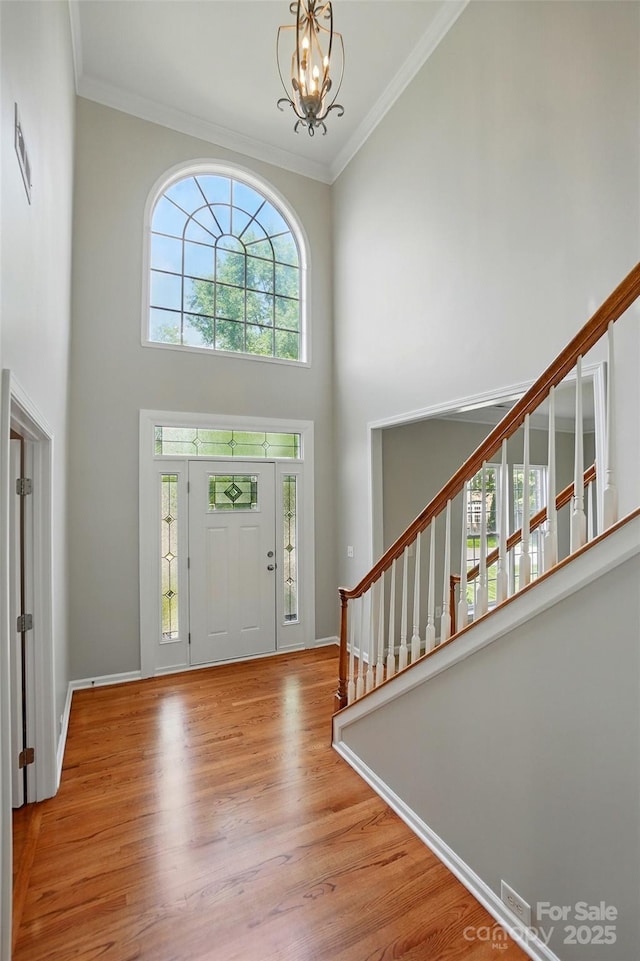 415 Glandon Ct, Fort Mill, SC 29708 - entryway featuring a towering ceiling, stairs, wood finished floors, a chandelier, and crown molding