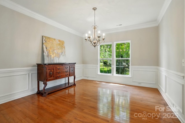 415 Glandon Ct, Fort Mill, SC 29708 - spare room with a chandelier, wood finished floors, a wainscoted wall, ornamental molding, and a decorative wall