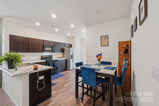 1770 Troon Dr, Salisbury, NC 28144 - kitchen featuring black appliances, dark brown cabinets, recessed lighting, light wood finished floors, and a peninsula