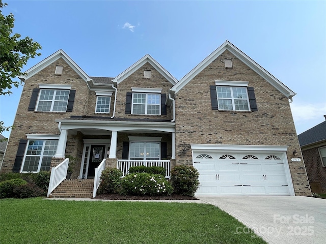 707 Five Leaf Ln, Waxhaw, NC 28173 - view of front of home with driveway, brick siding, a front lawn, and covered porch