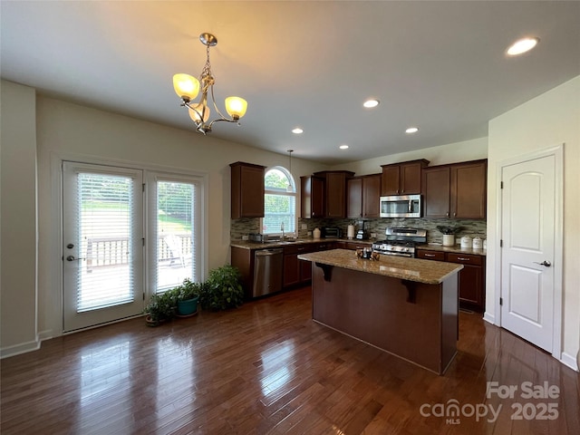 707 Five Leaf Ln, Waxhaw, NC 28173 - kitchen with appliances with stainless steel finishes, a sink, a chandelier, tasteful backsplash, and a center island