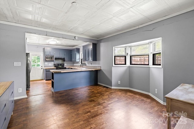 935 Church St, Kings Mountain, NC 28086 - kitchen with a peninsula, freestanding refrigerator, dark wood-type flooring, electric range, and light countertops