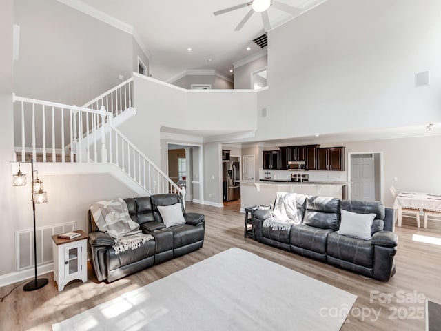 537 Montgrove Pl NW, Concord, NC 28027 - living area featuring a high ceiling, light wood-style flooring, stairway, a ceiling fan, and crown molding