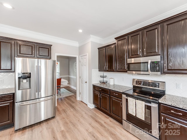 537 Montgrove Pl NW, Concord, NC 28027 - kitchen with appliances with stainless steel finishes, decorative backsplash, dark brown cabinetry, light wood-type flooring, and crown molding