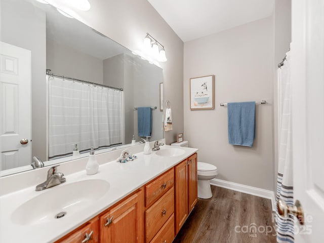 537 Montgrove Pl NW, Concord, NC 28027 - full bathroom with wood finished floors, toilet, double vanity, and baseboards