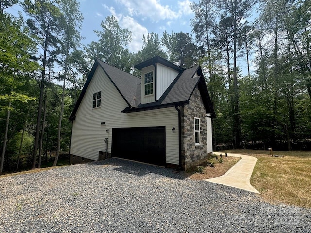 248 Pioneer Dr, Mount Gilead, NC 27306 - view of side of home with gravel driveway, a garage, stone siding, crawl space, and a shingled roof