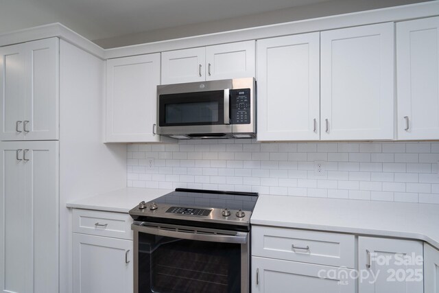 248 Pioneer Dr, Mount Gilead, NC 27306 - kitchen featuring appliances with stainless steel finishes, light countertops, tasteful backsplash, and white cabinetry