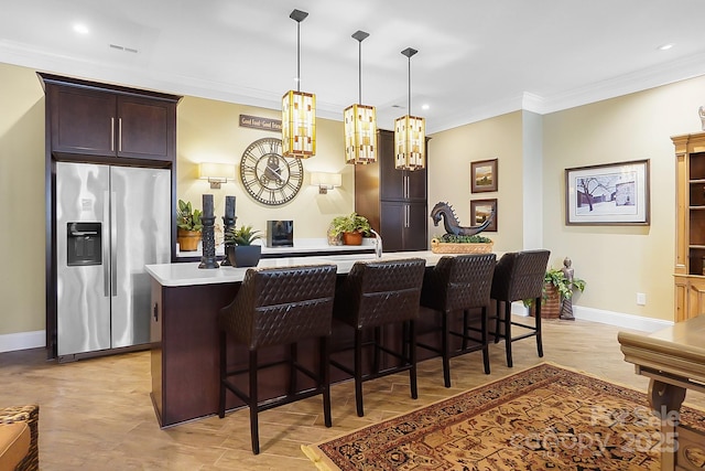 2354 Valelake Rd, York, SC 29745 - kitchen with stainless steel fridge with ice dispenser, baseboards, light countertops, ornamental molding, and a kitchen bar