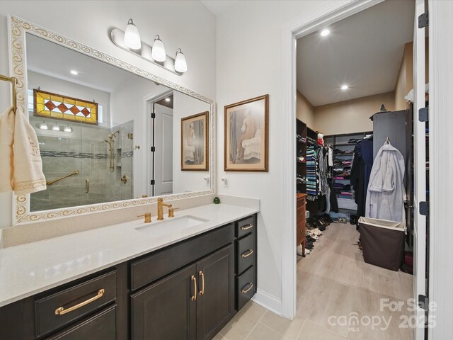 6015 Waldorf Ave, Monroe, NC 28110 - full bath featuring a walk in closet, vanity, a stall shower, tile patterned flooring, and baseboards