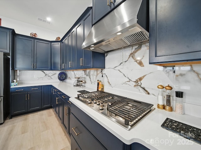 6015 Waldorf Ave, Monroe, NC 28110 - kitchen featuring under cabinet range hood, stainless steel gas stovetop, freestanding refrigerator, light countertops, and decorative backsplash