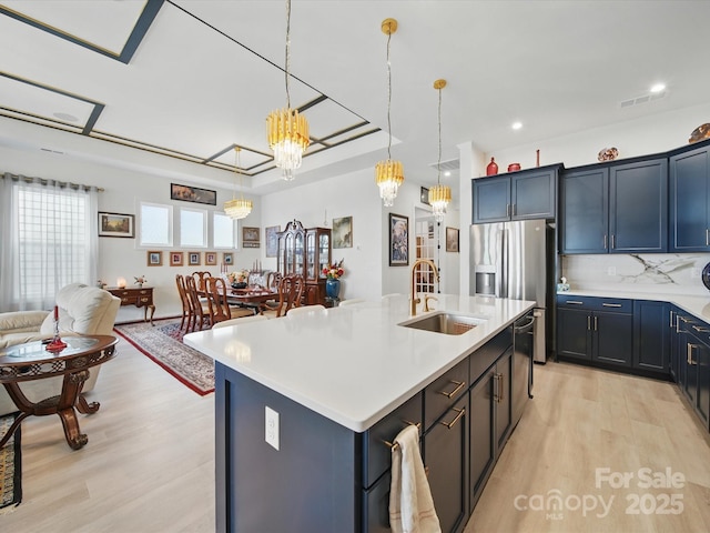 6015 Waldorf Ave, Monroe, NC 28110 - kitchen featuring a sink, light wood finished floors, stainless steel fridge with ice dispenser, a chandelier, and light countertops
