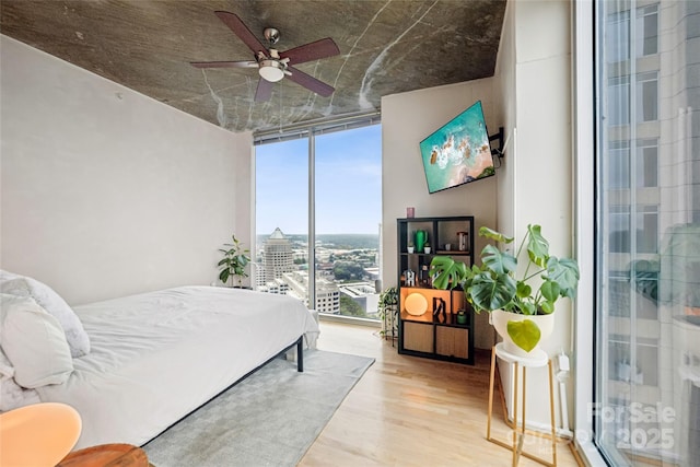 210 N Church St Unit 2807, Charlotte, NC 28202 - bedroom with expansive windows, wood finished floors, and a ceiling fan