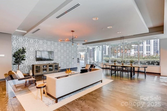 210 N Church St Unit 2807, Charlotte, NC 28202 - living area with wallpapered walls, wood finished floors, an accent wall, baseboards, and a chandelier