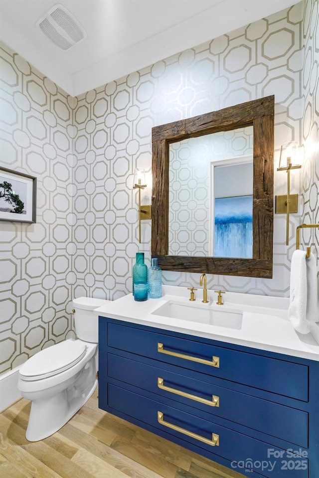 4211 Tangle Dr, Charlotte, NC 28211 - bathroom featuring toilet, vanity, wallpapered walls, and wood finished floors