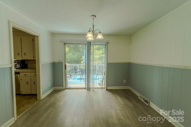 1867 Shannon Dr, Conover, NC 28613 - unfurnished dining area featuring wood finished floors, a chandelier, and a textured ceiling
