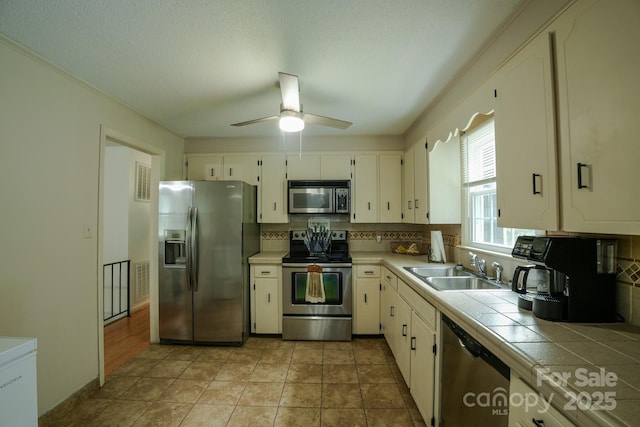 1867 Shannon Dr, Conover, NC 28613 - kitchen with stainless steel appliances, tile countertops, decorative backsplash, and a sink