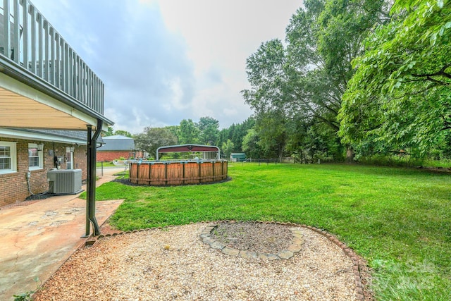 1867 Shannon Dr, Conover, NC 28613 - view of grassy yard with central air condition unit, a patio area, and an outdoor pool