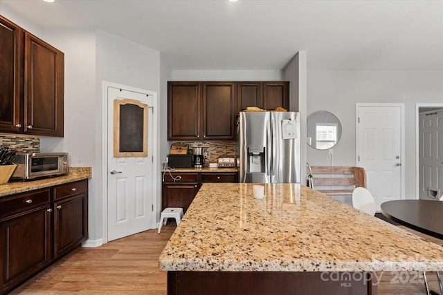 197 Roanoke Rd, Fletcher, NC 28732 - kitchen with stainless steel refrigerator with ice dispenser, light wood-style flooring, backsplash, light stone countertops, and a kitchen island