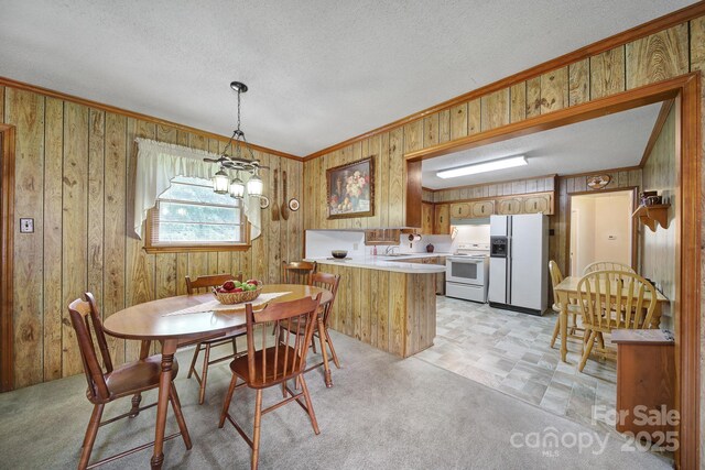 2084 Old Evans Cir, Lancaster, SC 29720 - dining space with ornamental molding, wooden walls, a chandelier, and a textured ceiling