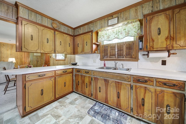 2084 Old Evans Cir, Lancaster, SC 29720 - kitchen with a sink, brown cabinets, a peninsula, light countertops, and ornamental molding