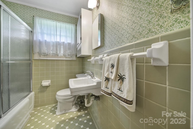 2084 Old Evans Cir, Lancaster, SC 29720 - bathroom with wallpapered walls, tile walls, combined bath / shower with glass door, a sink, and toilet