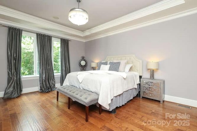 1103 Mapesbury Ln, Waxhaw, NC 28173 - bedroom with ornamental molding, wood finished floors, baseboards, and a tray ceiling
