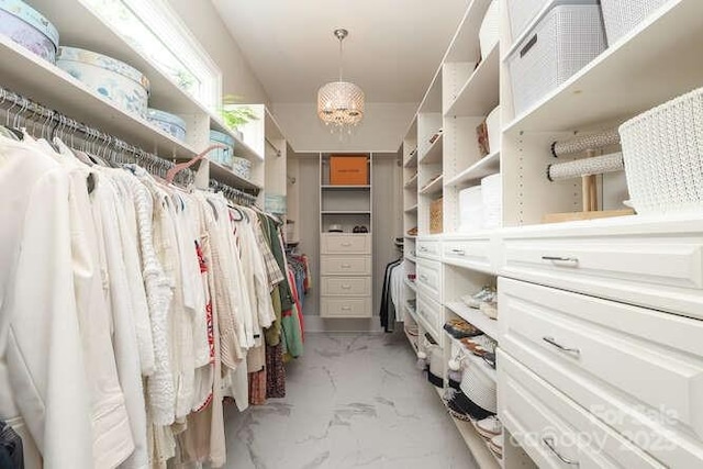 1103 Mapesbury Ln, Waxhaw, NC 28173 - walk in closet featuring light marble finish flooring and a chandelier