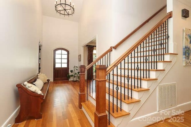 1103 Mapesbury Ln, Waxhaw, NC 28173 - entryway with wood finished floors, stairs, a chandelier, a towering ceiling, and baseboards