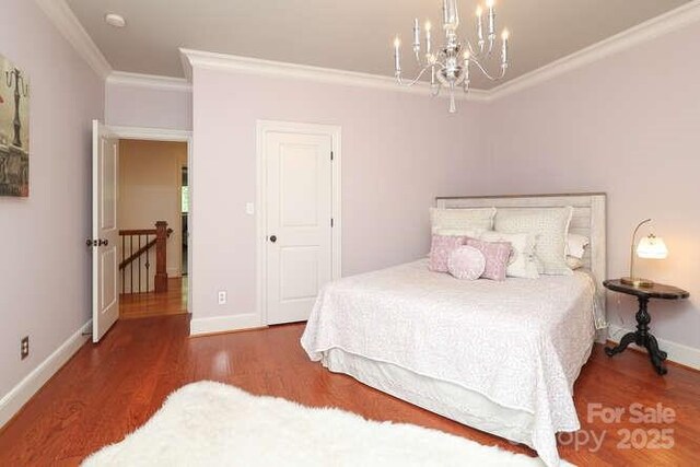1103 Mapesbury Ln, Waxhaw, NC 28173 - bedroom with crown molding, wood finished floors, a chandelier, and baseboards