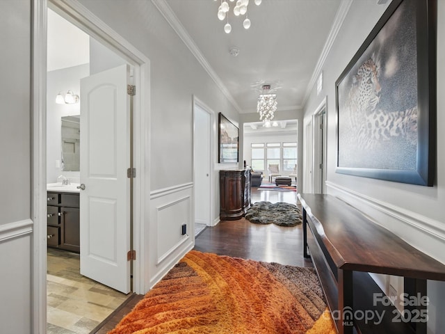 11225 Island View Ln, Lancaster, SC 29720 - hallway with a chandelier, wood finished floors, ornamental molding, a sink, and wainscoting