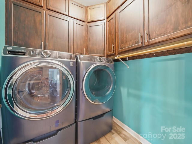 11225 Island View Ln, Lancaster, SC 29720 - laundry room with cabinet space, separate washer and dryer, light wood-type flooring, and baseboards