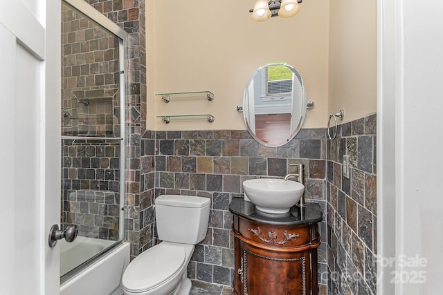 135 Waycross Dr, Rockwell, NC 28110 - bathroom with tile walls, vanity, toilet, shower / bath combination with glass door, and a wainscoted wall