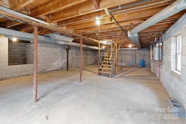 2599/2611 Old Mars Hill Hwy, Weaverville, NC 28787 - below grade area featuring stairway, a water pressure tank, water heater, and concrete block wall