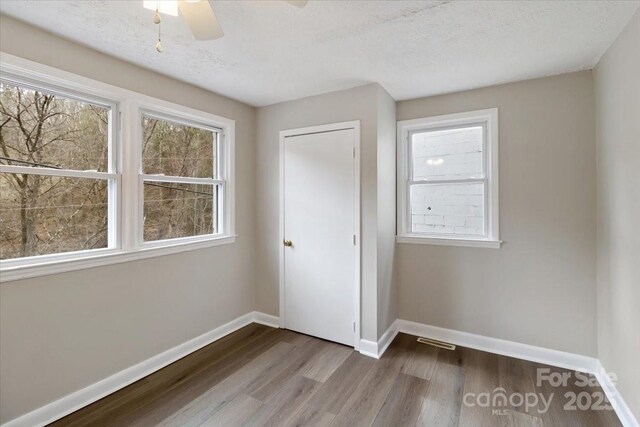 2599/2611 Old Mars Hill Hwy, Weaverville, NC 28787 - unfurnished bedroom with wood finished floors, baseboards, ceiling fan, and a textured ceiling