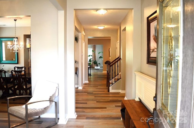 7170 Kenyon Dr, Denver, NC 28037 - hallway with light wood-style flooring, baseboards, a chandelier, and stairs