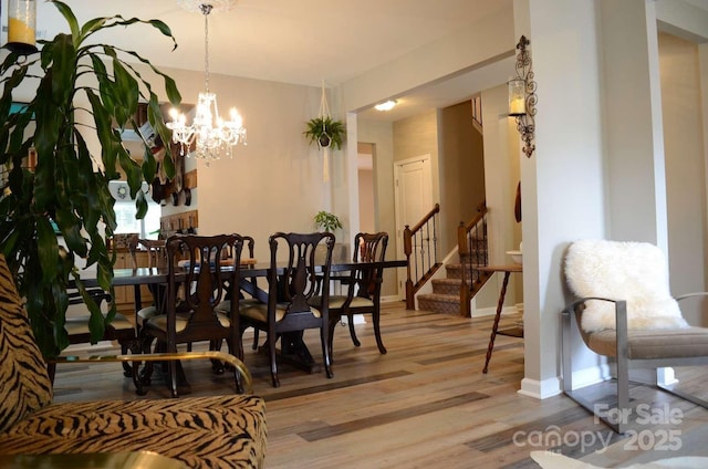 7170 Kenyon Dr, Denver, NC 28037 - dining room with light wood finished floors, stairway, a chandelier, and baseboards
