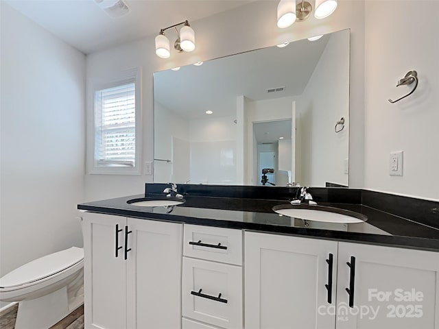 231 Brook Ave SE, Concord, NC 28025 - bathroom with double vanity, toilet, and wood finished floors
