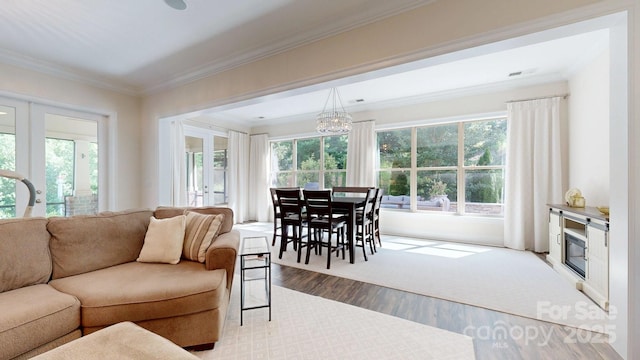 5590 Elk Knob Ct, Denver, NC 28037 - living room featuring wood finished floors, healthy amount of natural light, crown molding, and a chandelier