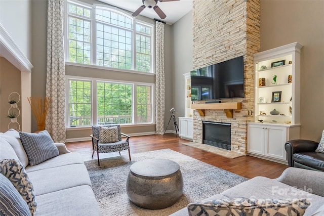 1868 Chestnut Hill Dr, Tega Cay, SC 29708 - living room featuring a high ceiling, wood finished floors, a fireplace, ceiling fan, and baseboards