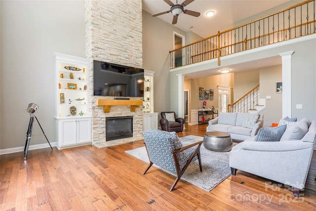 1868 Chestnut Hill Dr, Tega Cay, SC 29708 - living area featuring a high ceiling, ceiling fan, stairway, light wood finished floors, and a stone fireplace