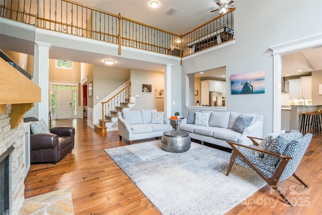 1868 Chestnut Hill Dr, Tega Cay, SC 29708 - living room with decorative columns, a high ceiling, light wood-style floors, stairway, and a ceiling fan