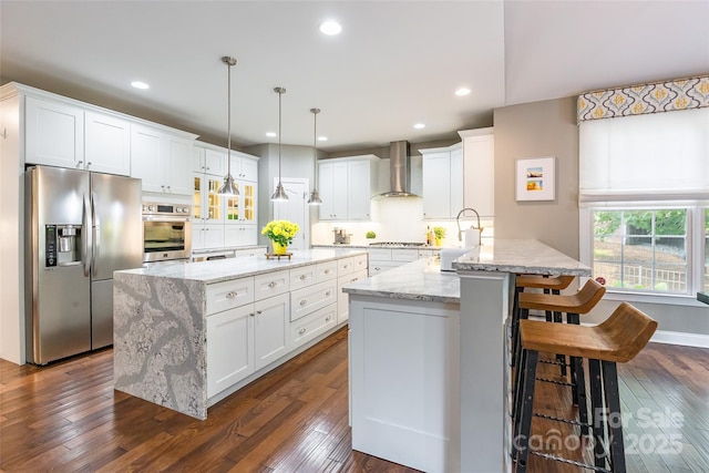 1868 Chestnut Hill Dr, Tega Cay, SC 29708 - kitchen with appliances with stainless steel finishes, wall chimney range hood, white cabinetry, a sink, and a kitchen breakfast bar